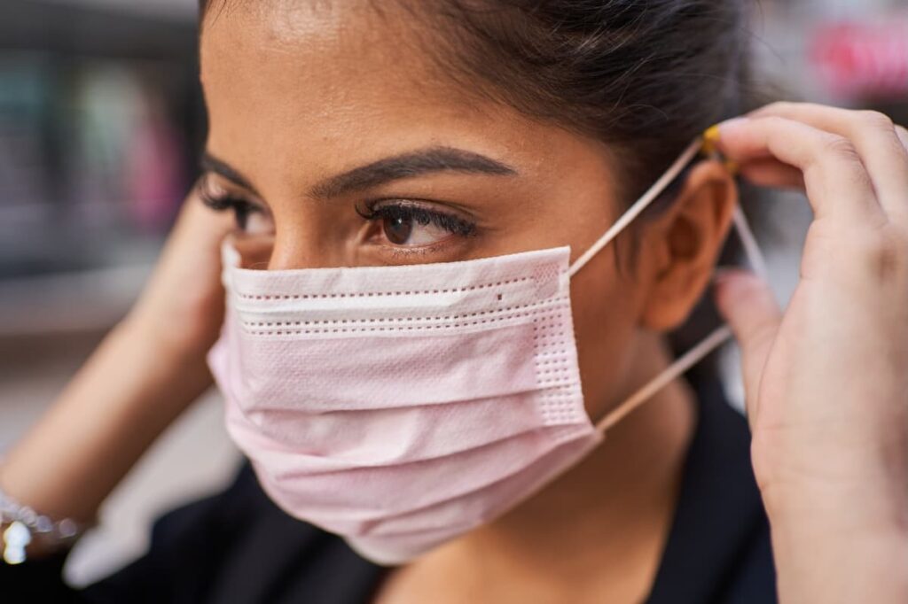 A woman wearing a surgical mask during a humanitarian crisis