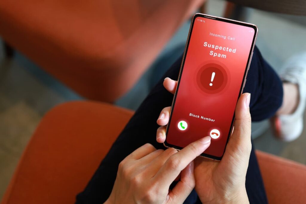 A person declining a suspected spam call on their phone