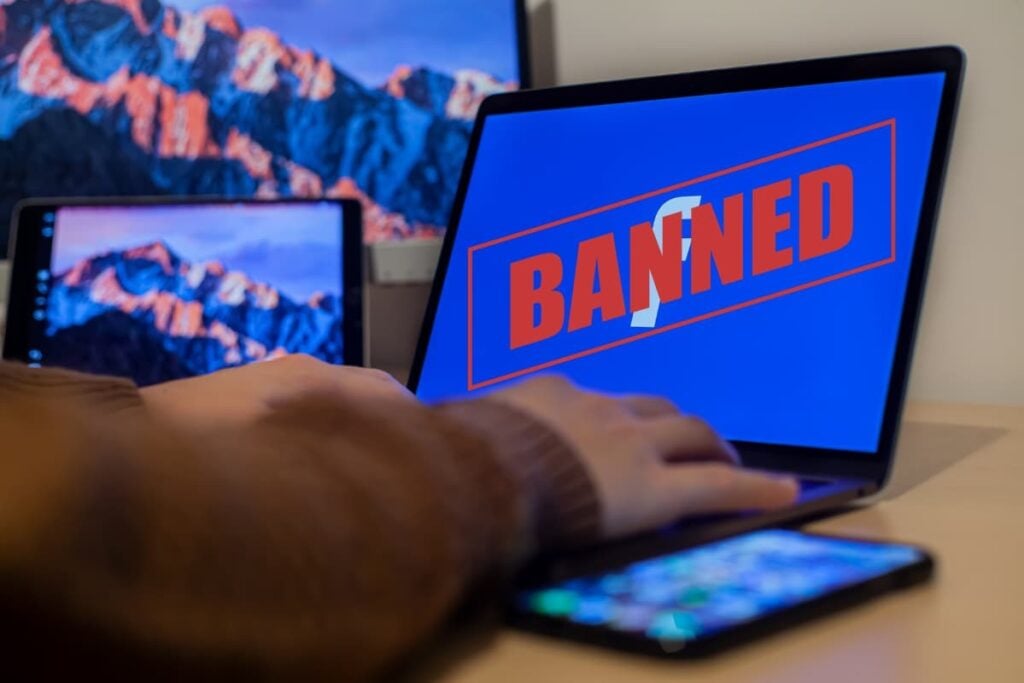 A person using a laptop with a banned facebook account