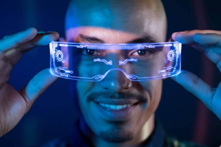 A person about to wear augmented reality glasses, with a neon blue glow, is looking directly at the viewer.