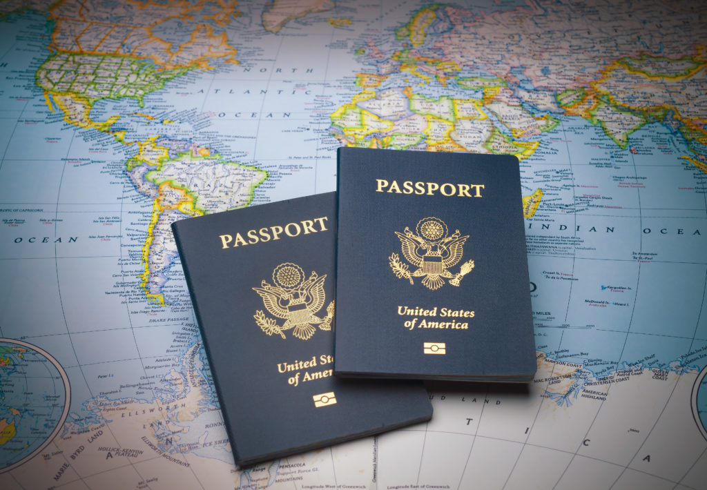 Two American passports - the keys to traveling internationally - on a map of the world.