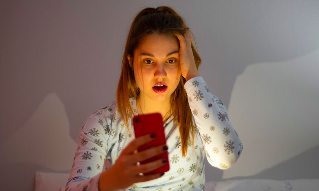 Shocked-looking girl on her smart phone.