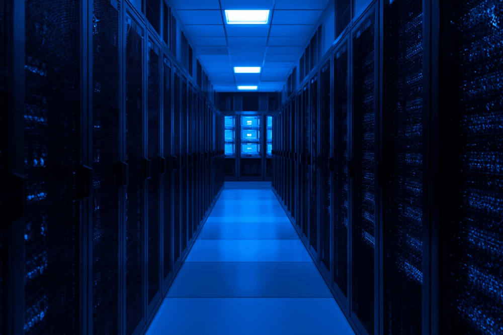 A modern server room illuminated in blue, representing secure data environments enhanced by machine-learning-driven cyber defense.