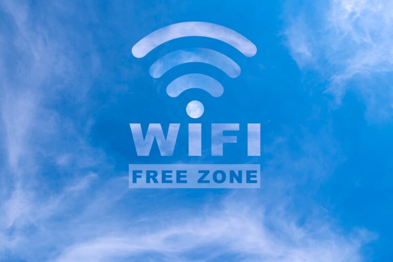 Free Wi-Fi sign against a clear blue sky.