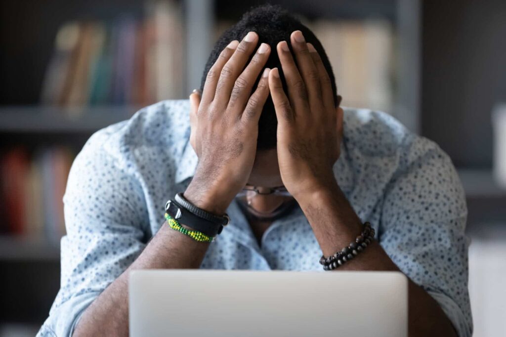 Man at a desk looking annoyed by an IP conflict error on his laptop.