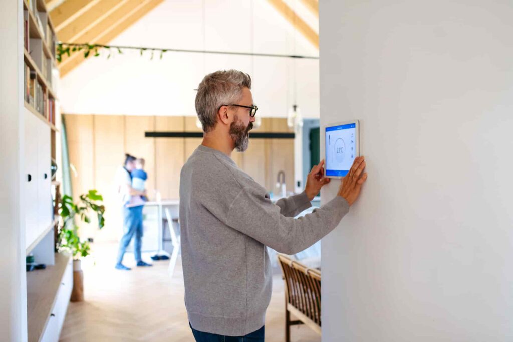Man using a smart home control panel to manage connected devices and home automation features.