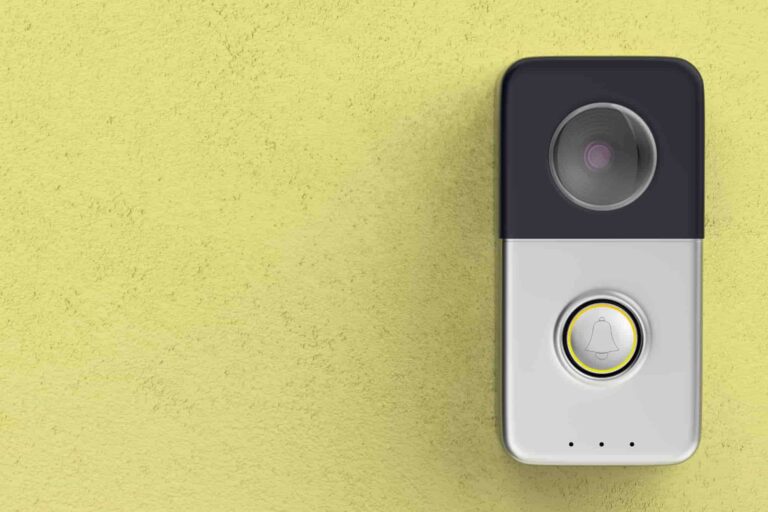 Smart doorbell mounted on a yellow exterior wall beside a home's entrance
