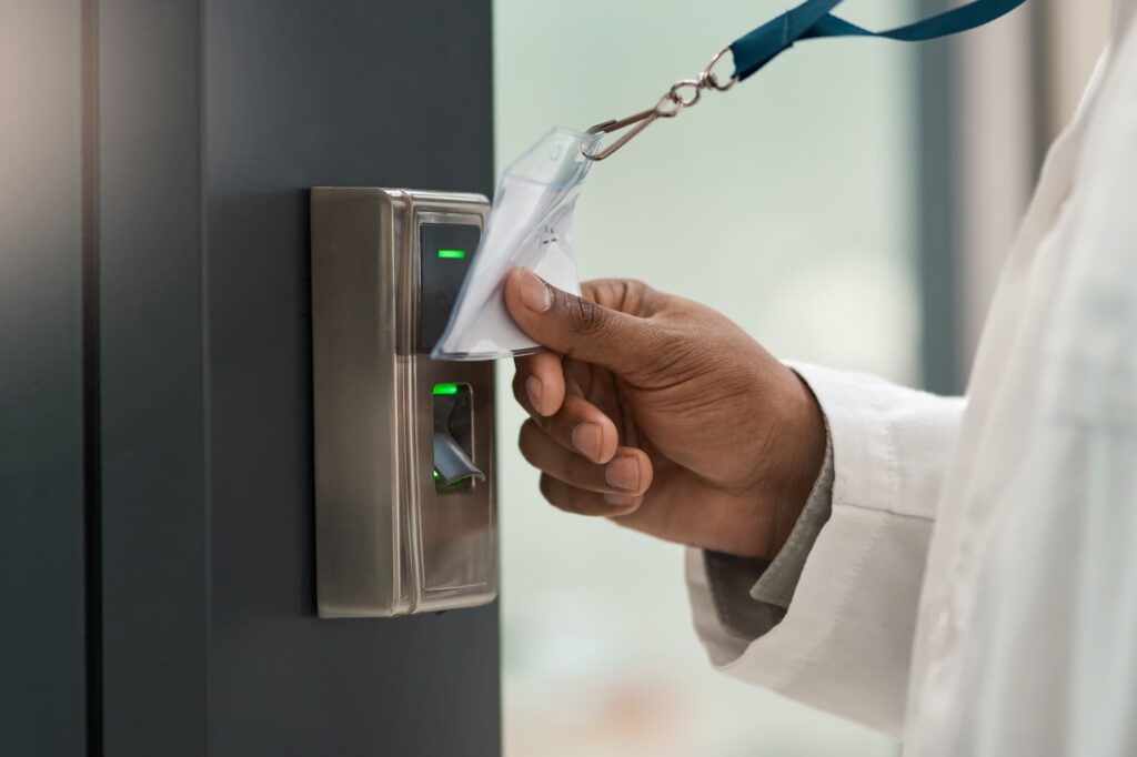 Hand scanning an NFC-enabled security access card at an electronic door reader